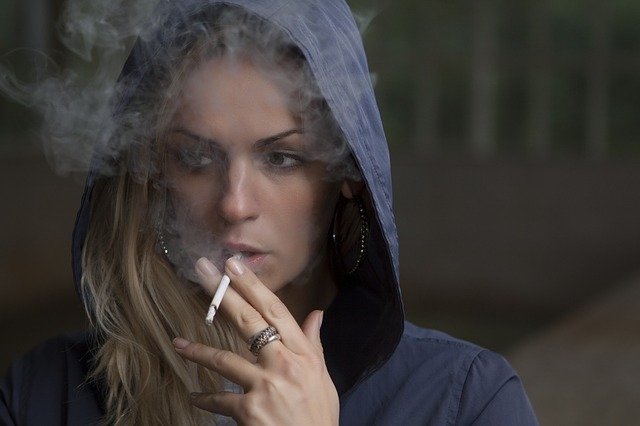 Žena v kapucni fajčí cigaretu.jpg